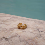 A handcrafted The Glade ring GP from the Cremilde Bispo Jewellery collection sitting on top of a marble pool.