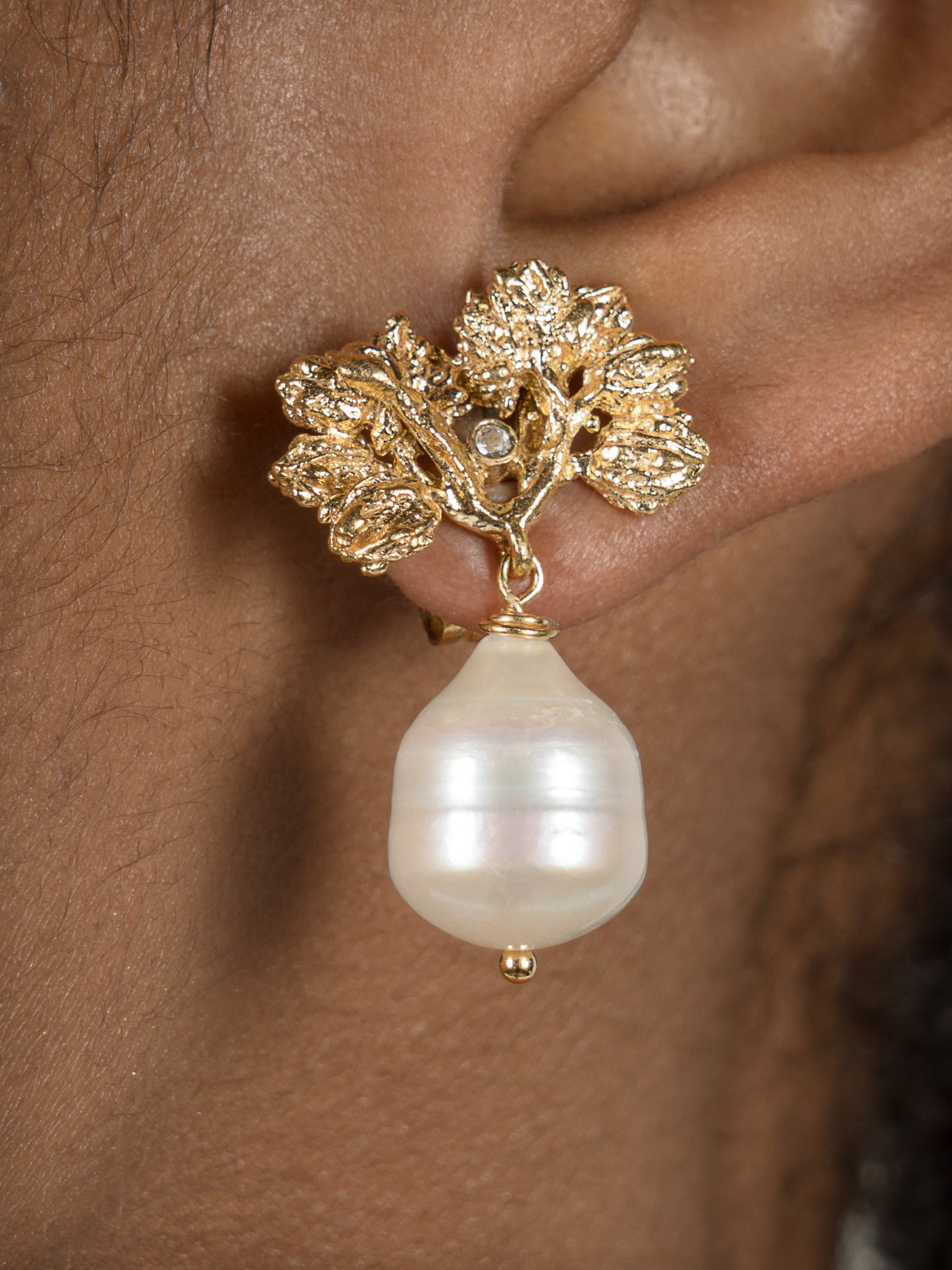 A woman's ear with the Pearly Forest Earrings GP by Cremilde Bispo Jewellery.
