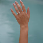 A woman's hand in Lisbon Atelier pool with a Cremilde Bispo Jewellery Valley ring on it.