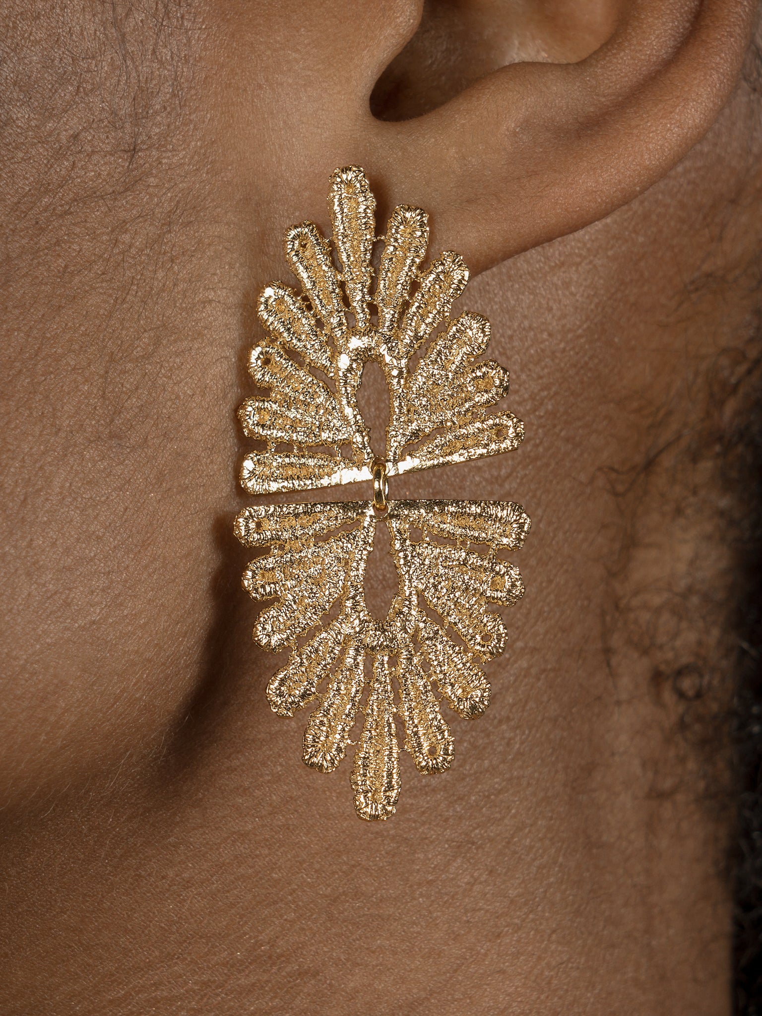A vintage-inspired Cremilde Bispo Jewellery woman's ear with The Guipure GP earring, showcasing lace artistry.
