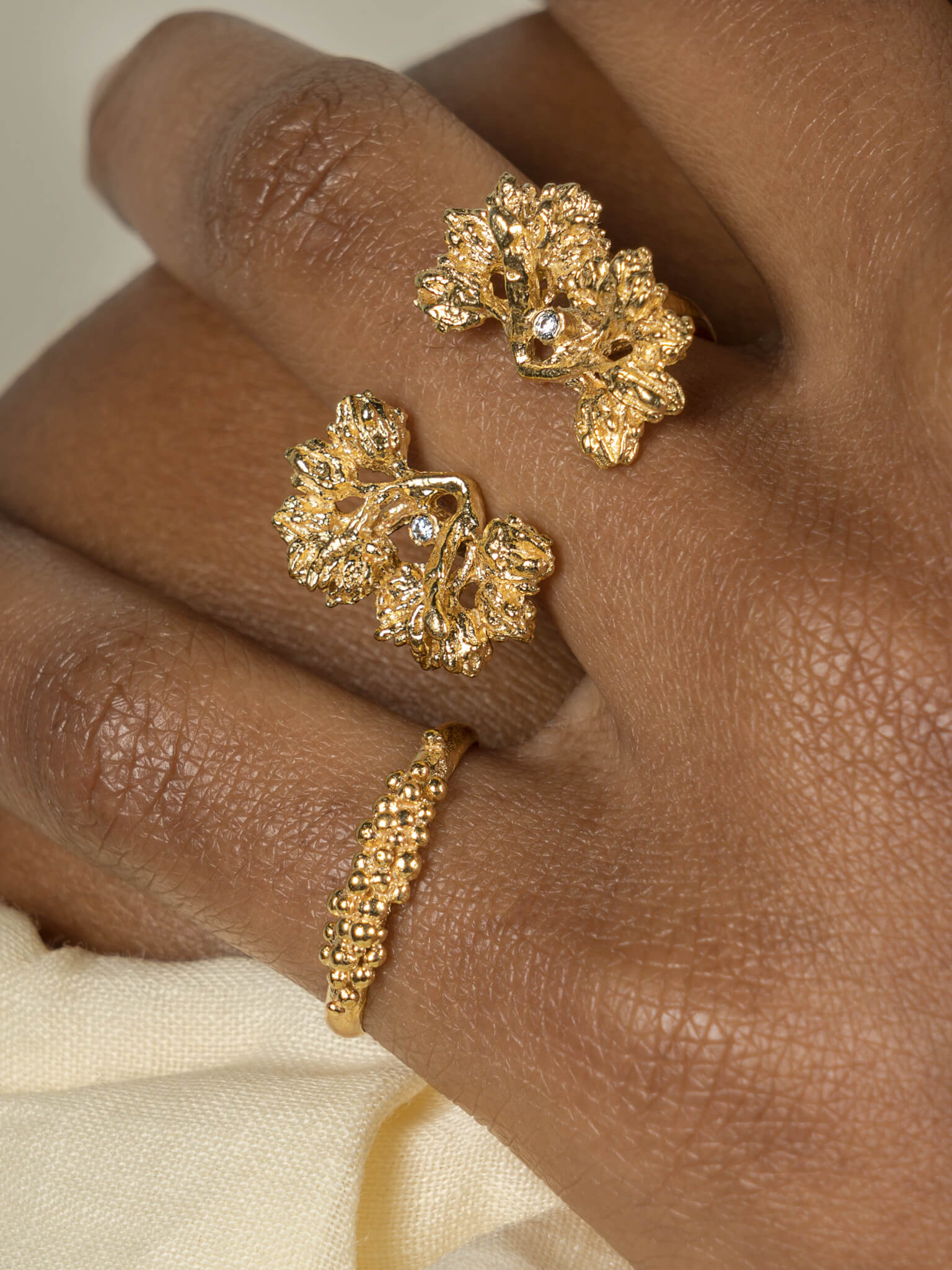 A woman's hand adorned with the Cremilde Bispo Jewellery Garden Ring GP, in gold plated Sterling Silver, featuring natural Quartz gemstones.