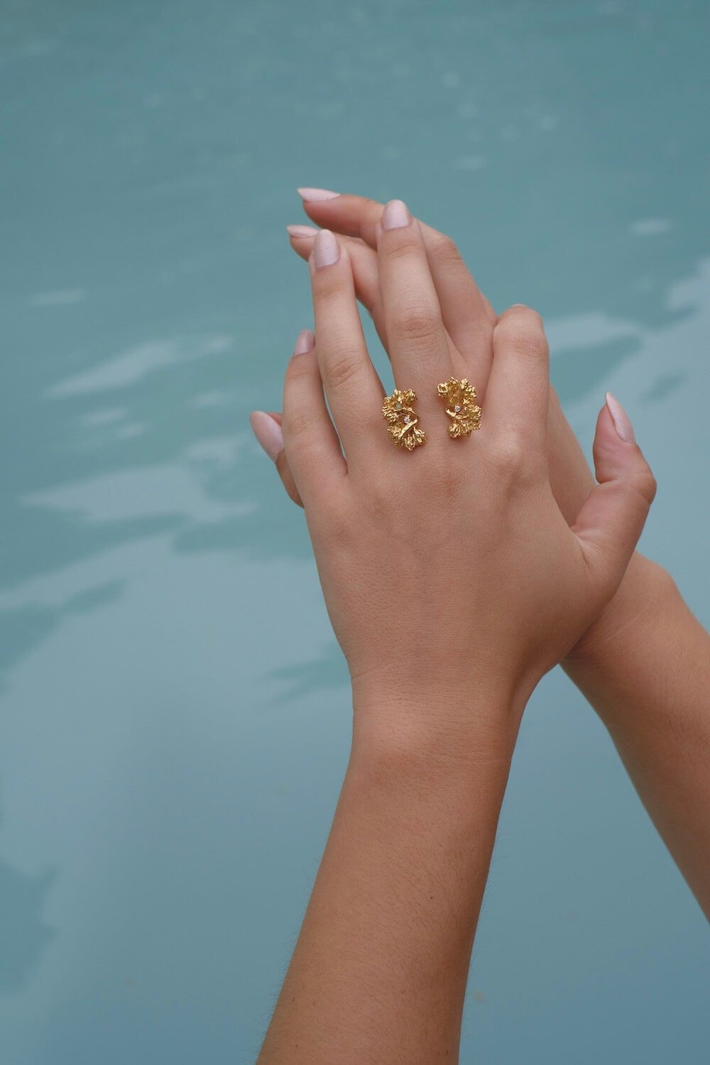 A woman's hand adorned with the Cremilde Bispo Jewellery Garden Ring GP, in gold plated Sterling Silver, featuring natural Quartz gemstones.