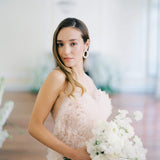 A refined bride in a pink dress holding a bouquet of white flowers, radiating nature's beauty with the Cremilde Bispo Jewellery's Garden's Delight earrings, in sterling silver.