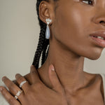 A woman wearing a pair of Muse III Chalcedony earrings, made of .925 silver by Cremilde Bispo Jewellery.