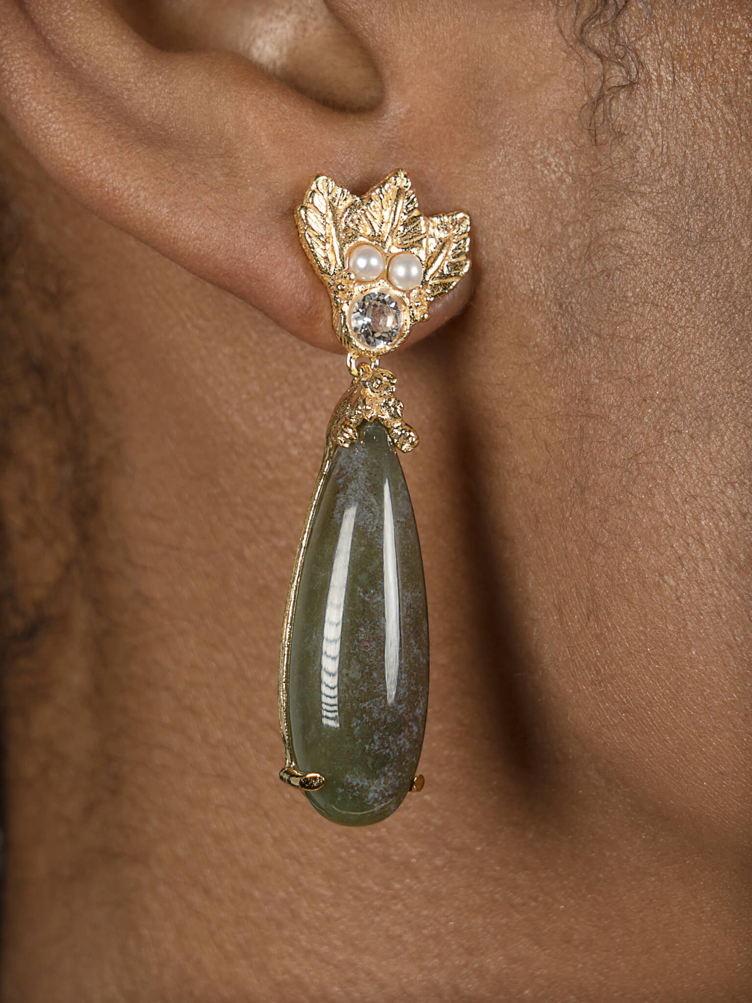A woman wearing a pair of Cremilde Bispo Jewellery's The Muse III Agata Moss earrings.