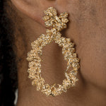 A woman showcasing opulence with a Cremilde Bispo Jewellery gold hoop earring, The Garden's Delight II GP.