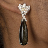 An elegant woman wearing a pair of The Muse III Obsidian earrings by Cremilde Bispo Jewellery, showcasing exquisite jewelry.