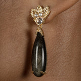 A woman wearing a pair of elegant Cremilde Bispo Jewellery's Muse III Obsidian earrings.