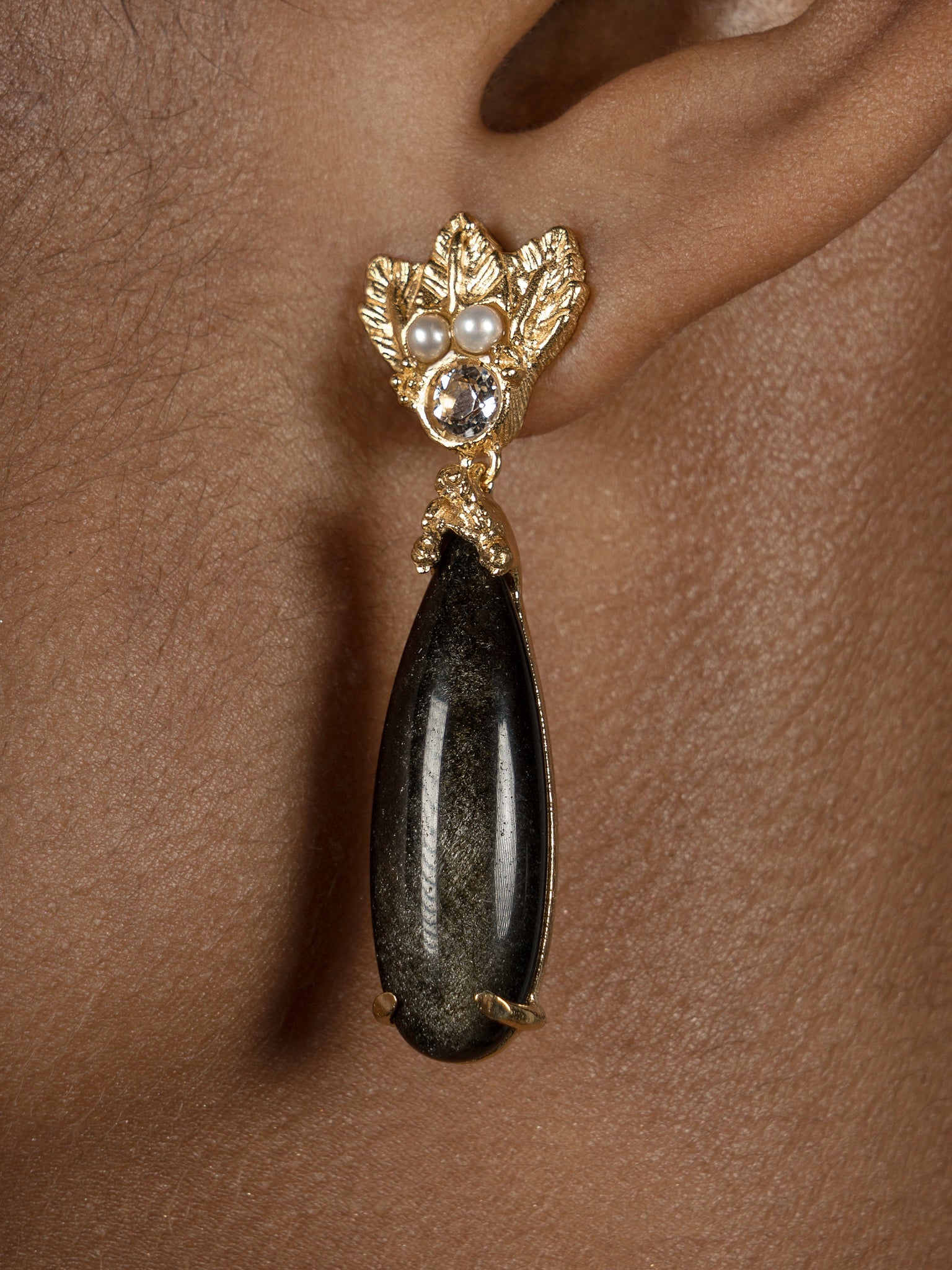 A woman wearing a pair of elegant Cremilde Bispo Jewellery's Muse III Obsidian earrings.