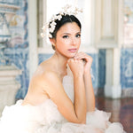 A luxurious woman in a white dress sitting on the floor, wearing The Muse I necklace by Cremilde Bispo Jewellery.