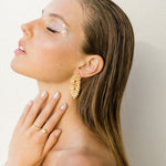 A woman wearing vintage-inspired Cremilde Bispo Jewellery Guipure GP Earrings and makeup.