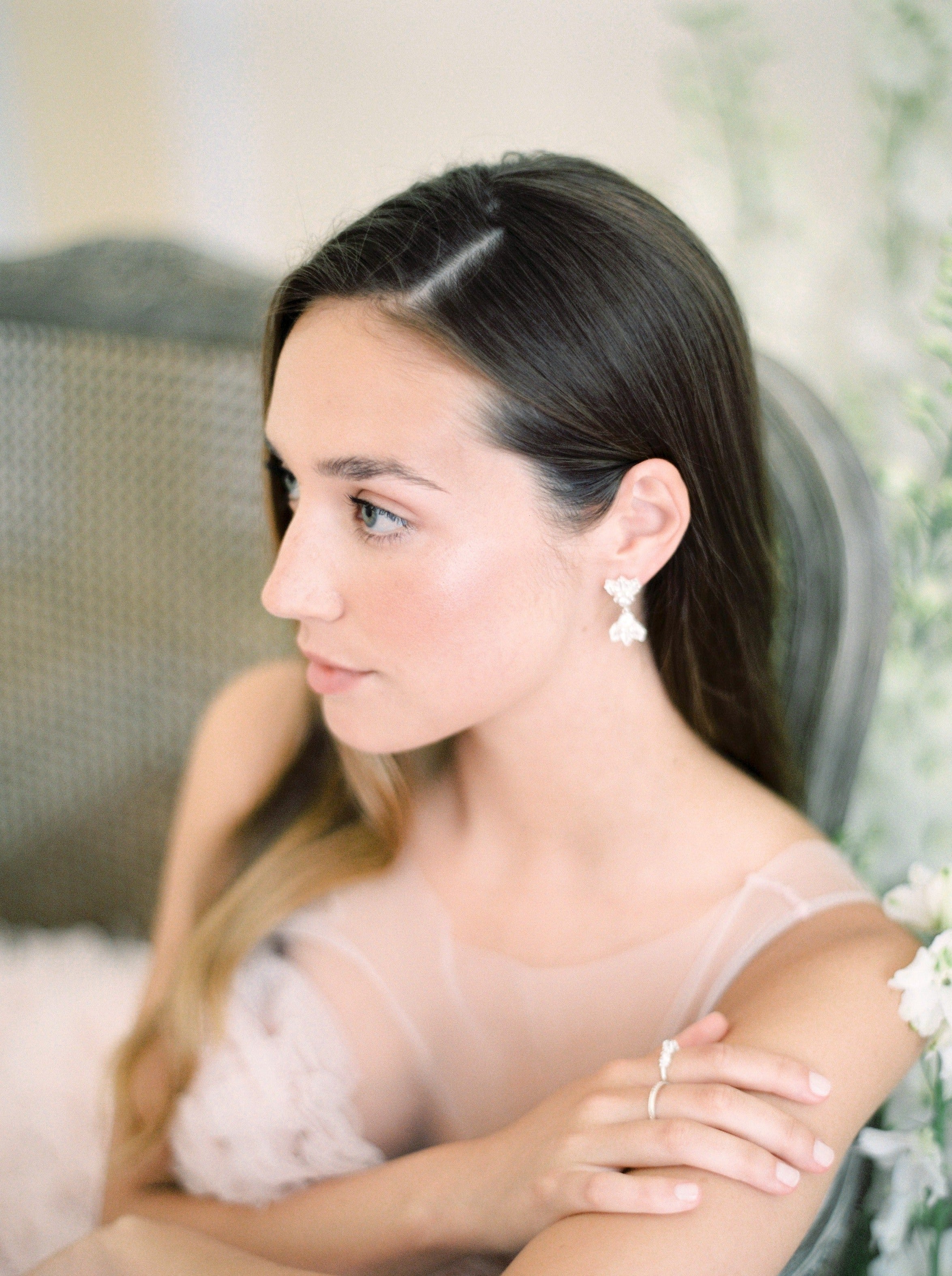 A Muse II of elegance in a luxurious pink dress, gracefully sitting on a chair by Cremilde Bispo Jewellery.