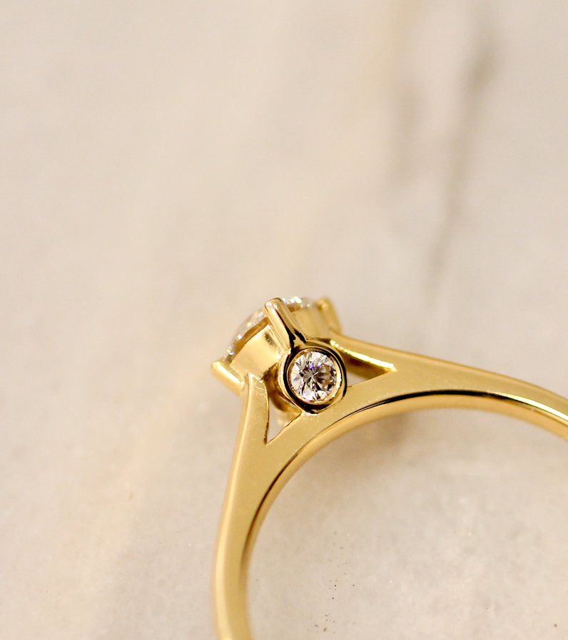 Bespoke 18K Engagement ring - a classic design with a twist that will take your breath away. The soul of this Ring is a 4.5mm Certified Diamond, flanked by two 2mm Diamonds, set into a timeless 18K yellow Gold band with North/South/East/West prongs.