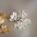 A pair of elegant silver earrings adorned with luxurious pearls and delicate leaves, inspired by the timeless beauty of the Cremilde Bispo Jewellery Muse II.