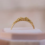 A timeless and elegant Cremilde Bispo Jewellery 18K GOLD Dots Diamond Ring delicately resting on top of a box.
