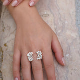 A close-up of a woman's hand wearing the handcrafted Garden Ring in sterling silver, embedded with Quartz gemstones, from Cremilde Bispo Jewellery.