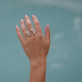 A close-up of a woman's hand wearing the handcrafted Garden Ring in sterling silver, embedded with Quartz gemstones, from Cremilde Bispo Jewellery.