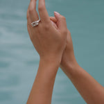 A woman's hand holding the Glade ring from Cremilde Bispo Jewellery in the water.