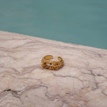 A handcrafted The Glade ring GP from the Cremilde Bispo Jewellery collection sitting on top of a marble pool.