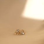 A pair of handcrafted The Muse I GP gold stud earrings on a beige background by Cremilde Bispo Jewellery.