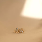 A pair of handcrafted The Muse I GP gold stud earrings on a beige background by Cremilde Bispo Jewellery.