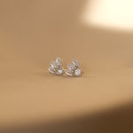 A pair of luxurious Cremilde Bispo Jewellery Muse I silver stud earrings on a table.