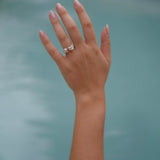 A woman's hand in Lisbon Atelier pool with a Cremilde Bispo Jewellery Valley ring on it.