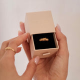 A woman holding The Blooms Ring in Gold plated sterling silver, by Cremilde Bispo Jewellery in the brand's gift jewellery box.