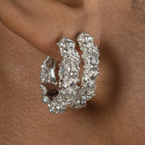 A close-up photo of a woman's hear featuring a pair of the Garden Hoops by Cremilde Bispo Jewellery in Sterling Silver.