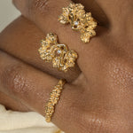 A woman's hand adorned with the Cremilde Bispo Jewellery Garden Ring GP, in gold plated Sterling Silver, featuring natural Quartz gemstones.
