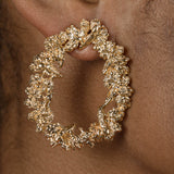 A woman's ear adorned with a Cremilde Bispo Jewellery Garden's Delight statement earrings, in gold plated sterling silver, with hand-sculpted nature inspired embellishments.