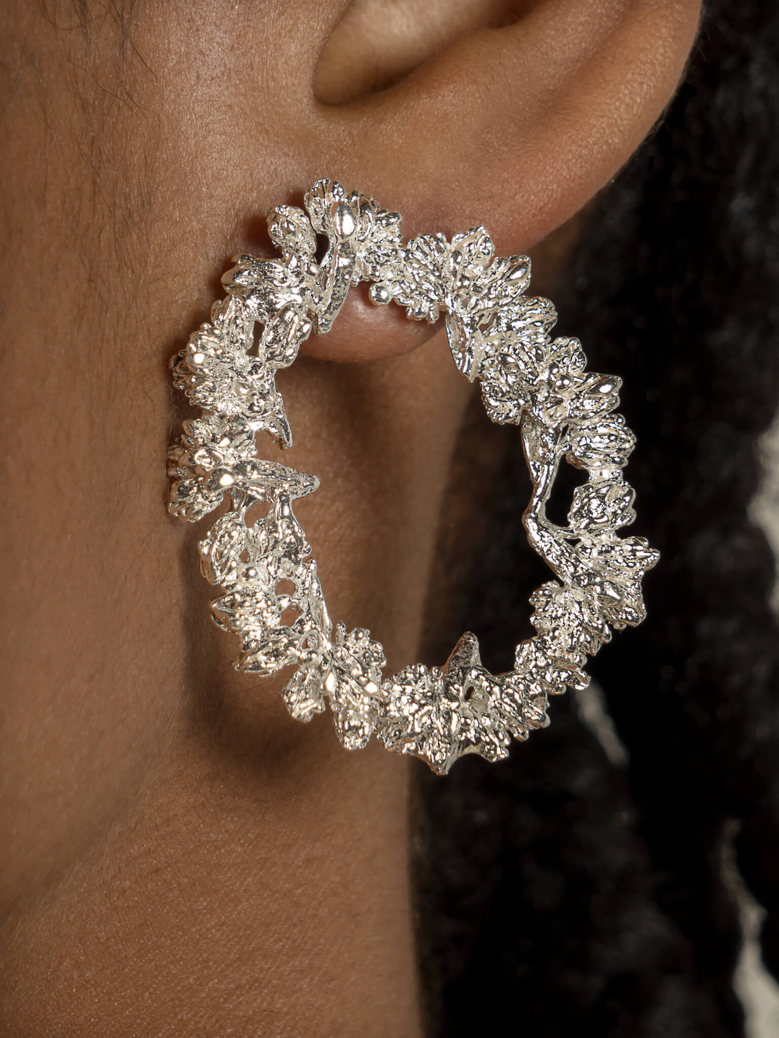 A close up of a woman's ear adorned with Cremilde Bispo Jewellery's Garden's Delight Earrings, radiating nature's beauty and refined elegance.