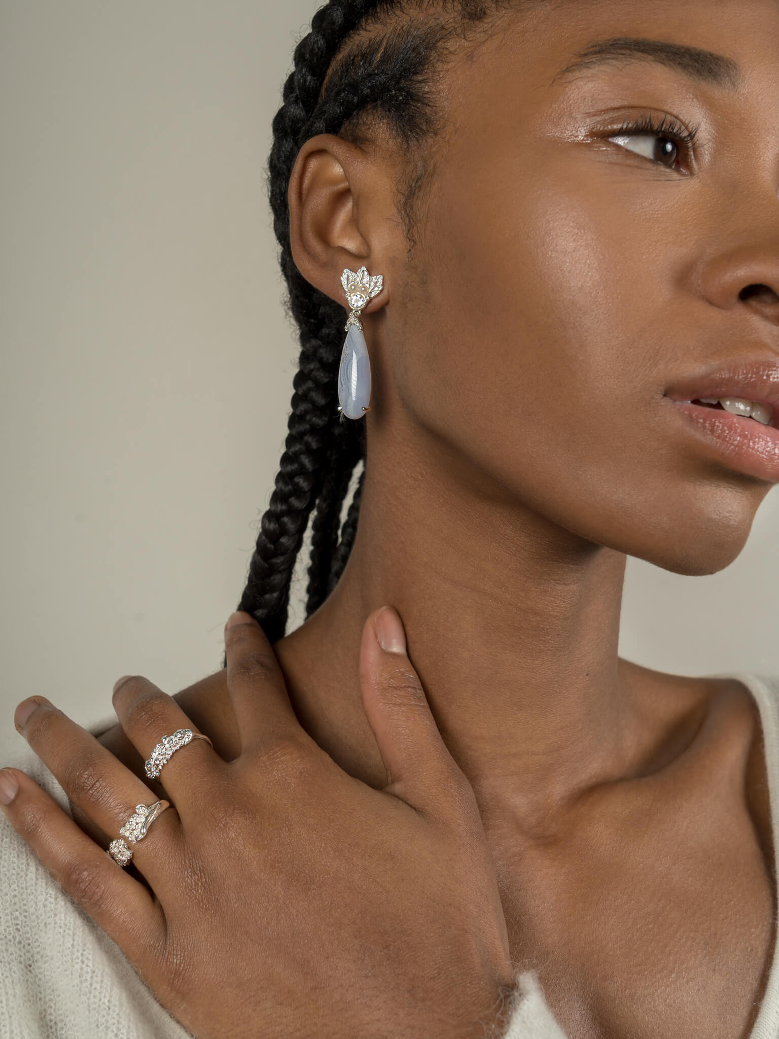 A woman wearing a pair of Muse III Chalcedony earrings, made of .925 silver by Cremilde Bispo Jewellery.