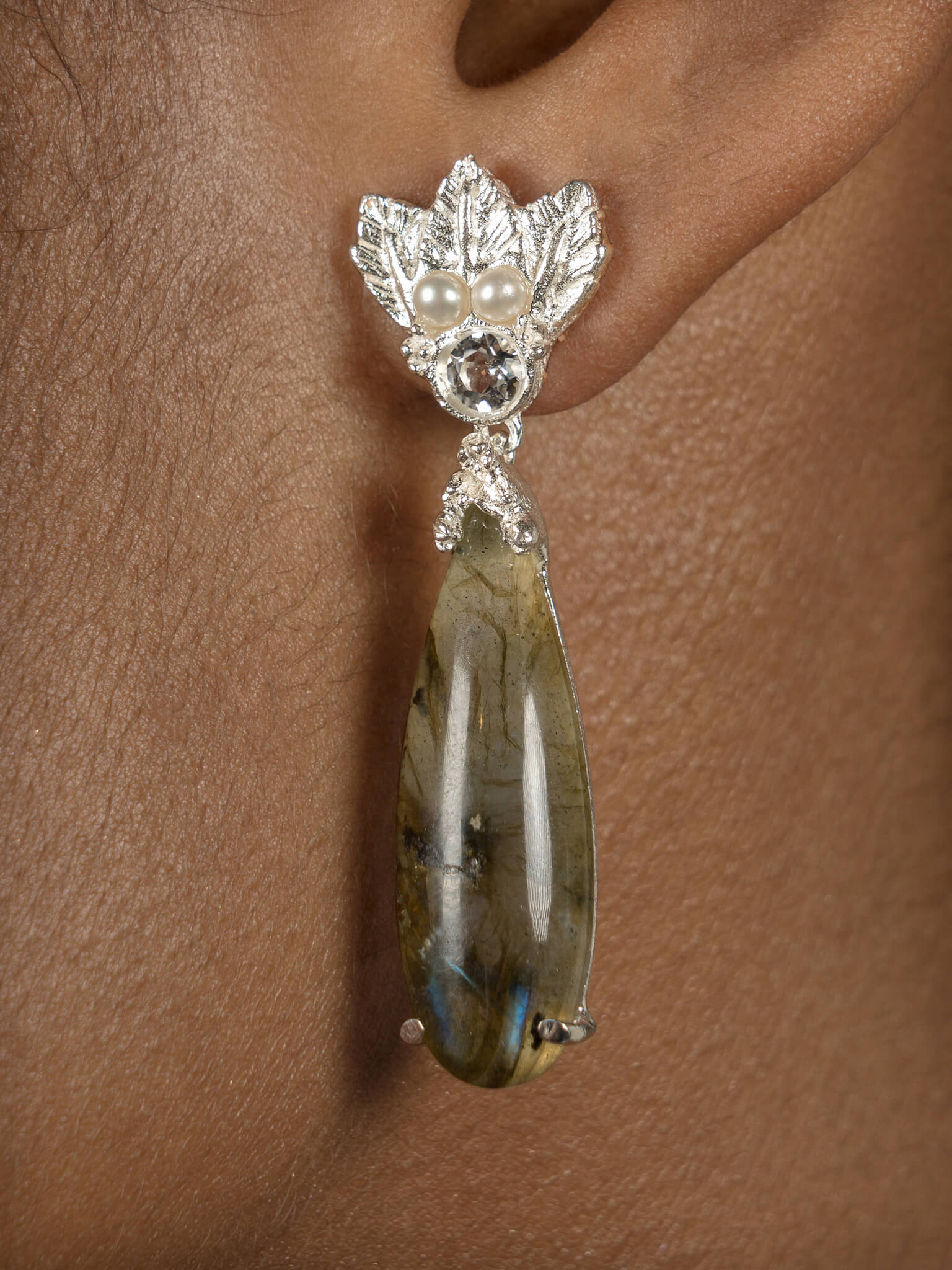 A woman wearing a pair of Cremilde Bispo Jewellery's Muse III Labradorite earrings with Quartz and pearls.