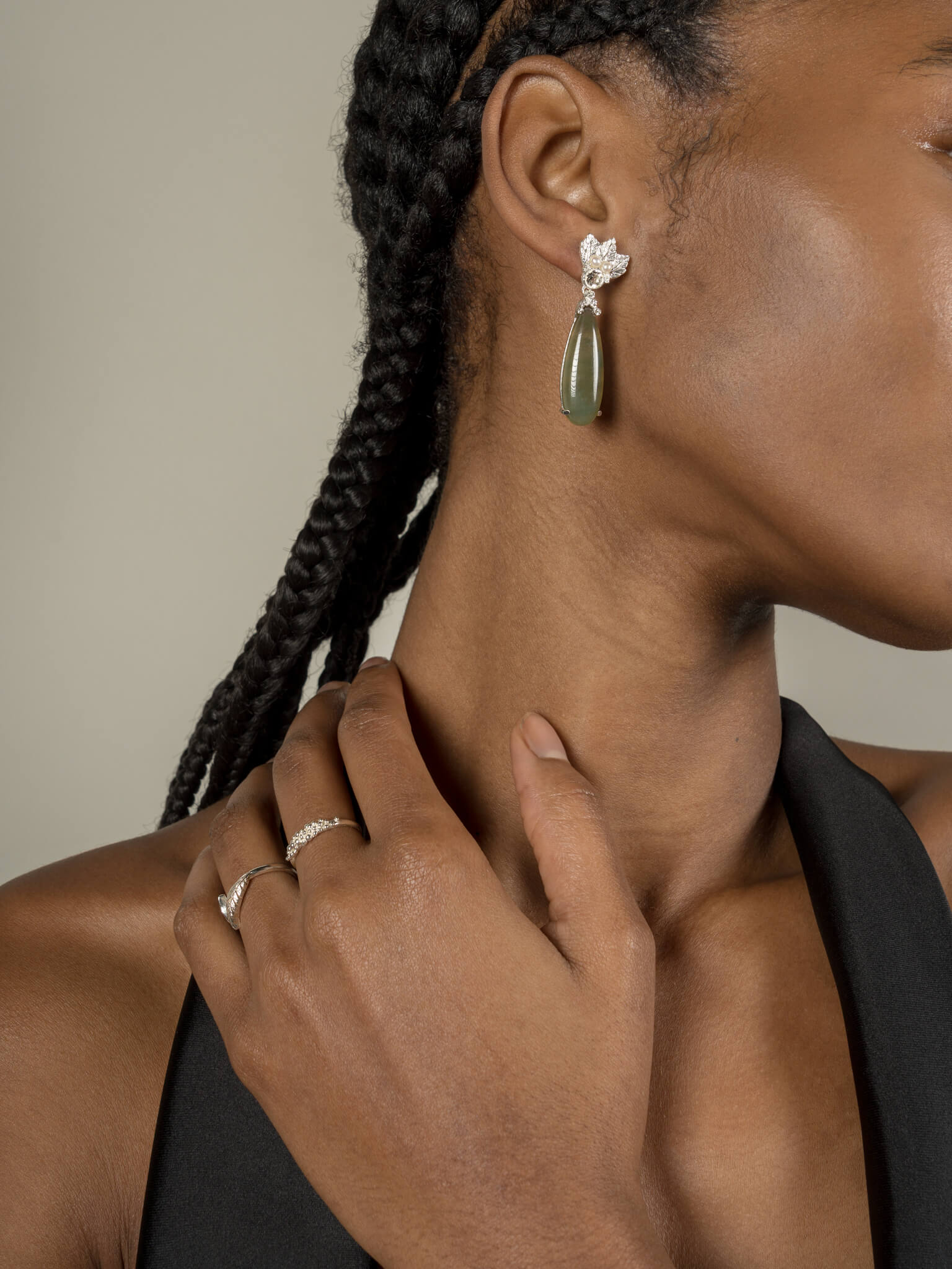 A woman wearing The Muse III Agata Moss earrings by Cremilde Bispo Jewellery and a black top.