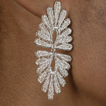 A close up of a woman's ear adorned with a pair of vintage-inspired silver Cremilde Bispo Jewellery Guipure Earrings, showcasing delicate lace artistry.