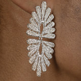 A close up of a woman's ear adorned with a pair of vintage-inspired silver Cremilde Bispo Jewellery Guipure Earrings, showcasing delicate lace artistry.