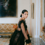 A sophisticated woman in a lavish black gown wearing the Cremilde Bispo Jewellery Garden's Delight statement earrings in sterling silver, posing in front of an luxury hotel mirror.