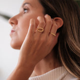A woman showcasing the 18K Yellow GOLD Essential Dot Ring from her Cremilde Bispo Jewellery collection.