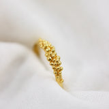 An exquisite Cremilde Bispo Jewellery 18K Yellow Gold Essential Dot Ring displayed elegantly on a white cloth, adding to the allure of your jewellery collection.