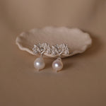 A pair of Cremilde Bispo Jewellery's Pearly Forest Earrings on a plate.
