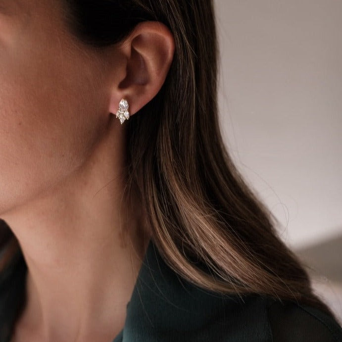 A woman wearing a green shirt showcasing her Cremilde Bispo Jewellery Essential Drops earrings.