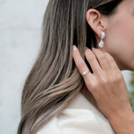 A woman with long hair wearing a pair of Cremilde Bispo Jewellery's 18k GOLD Hera Diamonds Ring.