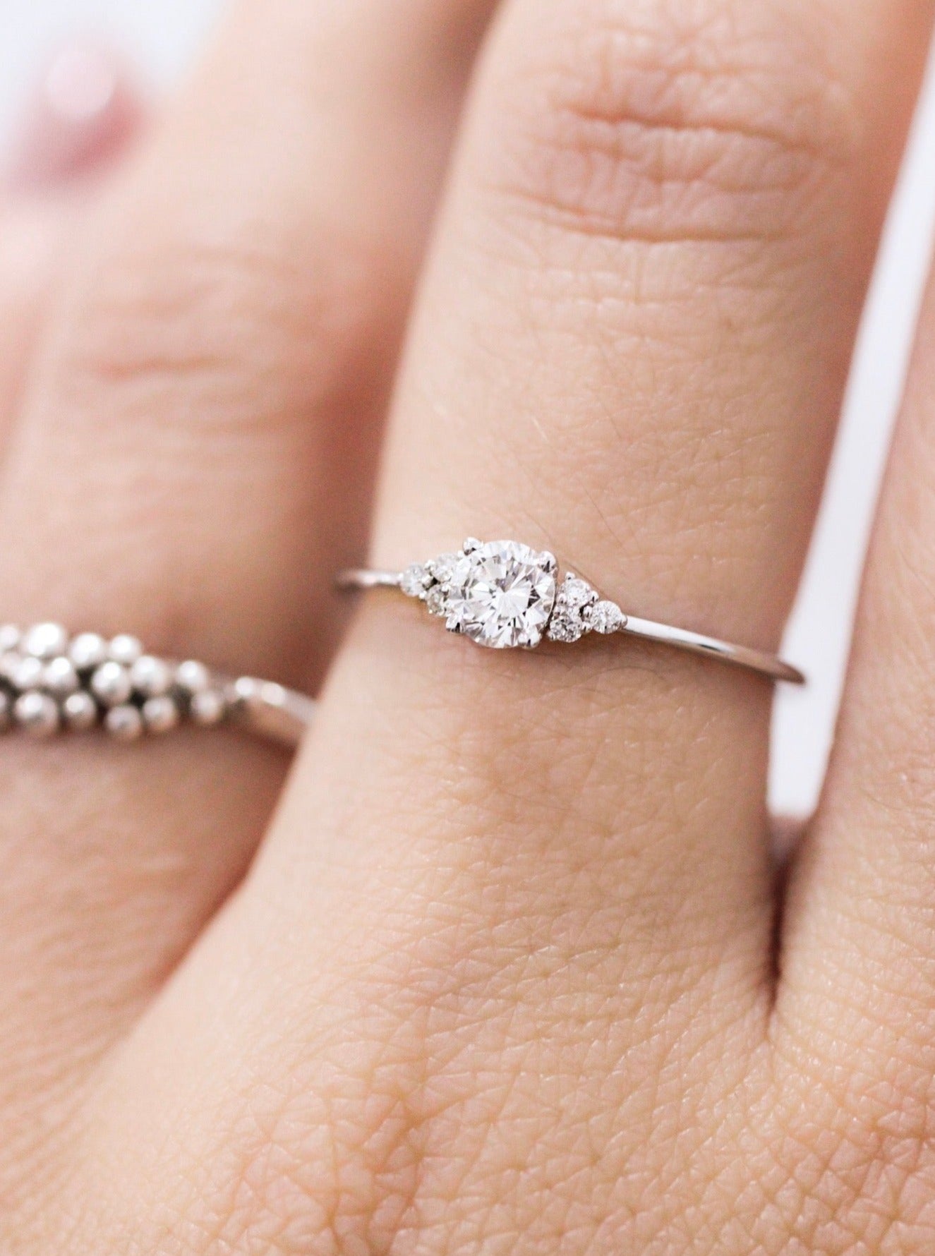 A woman's hand displaying a bespoke Cremilde Bispo Jewellery 18k GOLD Hera Diamonds ring, meticulously made-to-order.