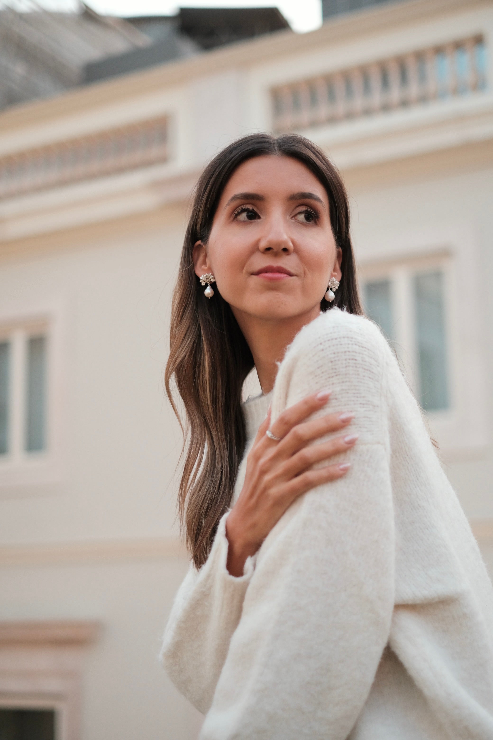 A woman wearing a white sweater and Cremilde Bispo Jewellery's The Pearly Forest Earrings made of sterling silver.