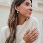 A woman wearing a white sweater and Cremilde Bispo Jewellery's The Pearly Forest Earrings.