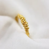 Gold plated ring with a front full of granites.