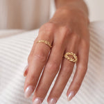 A woman's hand adorned with the Cremilde Bispo Jewellery Essential Dot Ring GP exudes timeless elegance and luxurious sophistication.