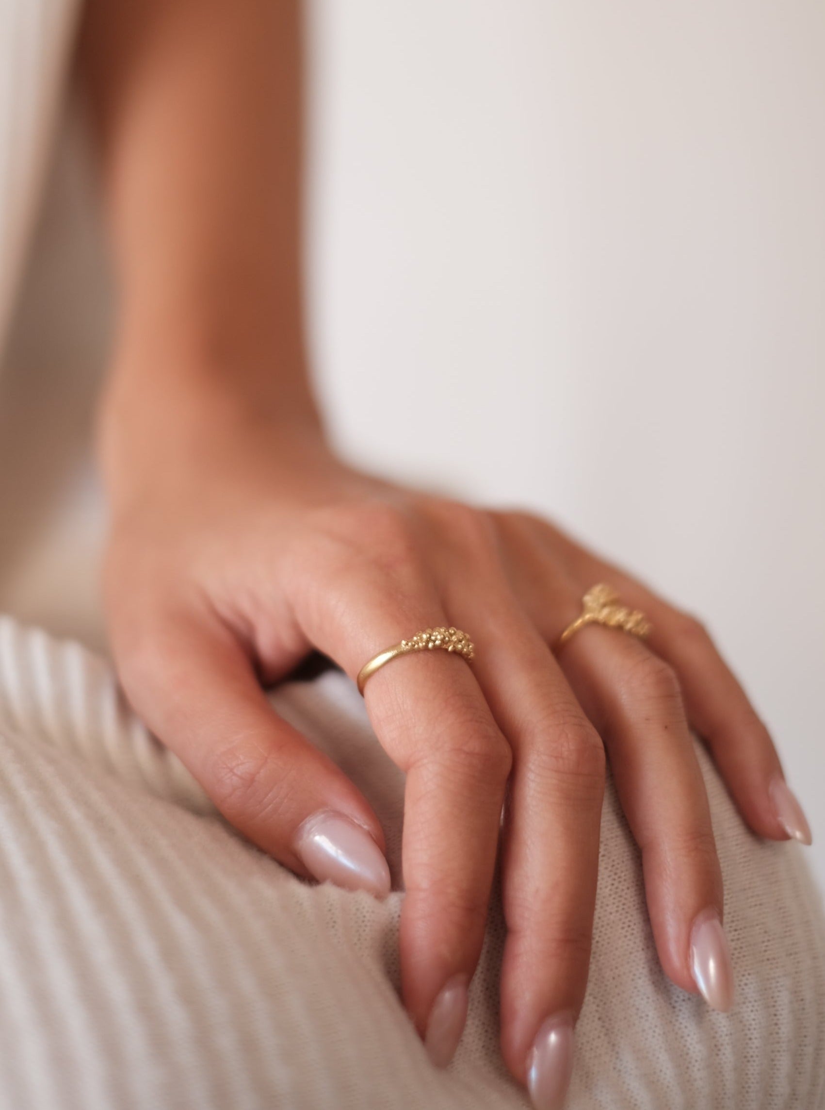 Experience timeless elegance with a woman's hand adorned by the Cremilde Bispo Jewellery Essential Dot Ring GP, capturing an exquisite and sophisticated look.
