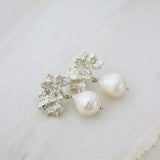 A pair of Cremilde Bispo Jewellery's Pearly Forest Earrings with Baroque Pearl accents on a marble surface.
